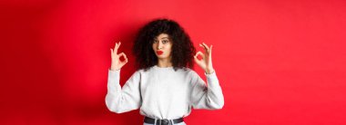 Fena değildi. Etkilenmiş kıvırcık kadın onaylamak için başını salladı, dudaklarını büzdü ve iyi işaretler gösterdi..