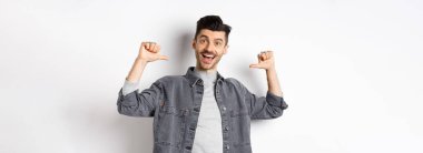 Yakışıklı ve kendine güvenen, gülümseyen, kendini üstün gören, profesyonel gibi hisseden, beyaz arka planda duran bir adam..