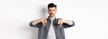 Hem de çok. Ciddi bir adam kameraya pokeryüz ile bakar, hayır der, onaylamaz ve beğenmez, beyaz arka planda tatminsiz durur..