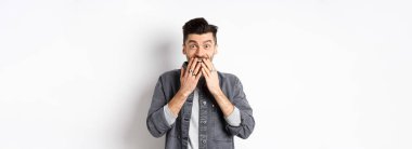 Mutluluktan gülen mutlu adam, şaşkınlık ve inançsızlıkla bak, hediyeyi al, beyaz arka planda dur..