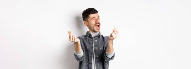 Komik adam göz kırpıyor, el işareti yapıyor, romantik ve mutlu hissediyor, beyaz arka planda duruyor..