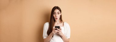 Akıllı telefonuyla hayrete düşmüş bir kız, 