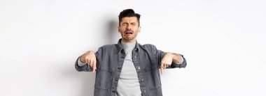 Üzgün, ağlayan, ağlayan, hıçkıra hıçkıra ağlayan, üzücü haberler veren, beyaz arka planda kot ceket giyen adam..