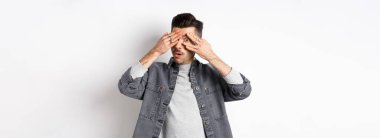 Çok ilginç. Meraklı bir adam kameraya bakıyor, şaşkın şaşkın bakıyor, beyaz arka planda duruyor..