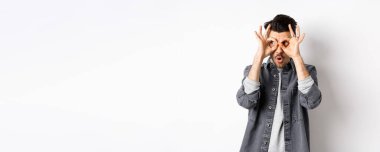 Komik adam el dürbününden bakıyor, muhteşem tanıtımlara bakıyor, 