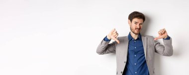 Berbat bir durum. Adam kötü bir şey gösterip yargılarken kendini garip hissediyor. Hayal kırıklığına uğruyor, beyaz arka planda takım elbise içinde duruyor..