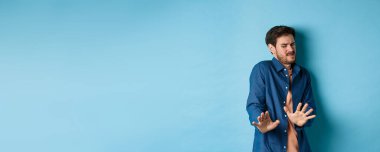 Bir adamın görüntüsü tiksindirici ve iğrenç bir şeye bakar, korkunç bir şeyden uzaklaşır ve mavi arka planda durarak onu engeller. Boşluğu kopyala