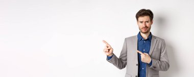 Kötü bir fikir. Memnun olmayan şüpheci takım elbiseli adam sırıtıyor ve kaşlarını çatıyor. Üzücü haberleri işaret ediyor. Kameraya tereddütlü bakıyor..