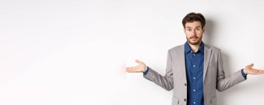 - Bilmiyorum. Kafası karışmış işadamı ellerini yana açmış ve cahil görünüyor, yardımcı olamıyor, hiçbir fikrim yok, takım elbise içinde beyaz arka planda duruyor..