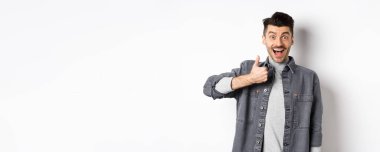 Aferin, çok iyi. Heyecanlı yakışıklı adam güzel işi övüyor, parmağını kaldırıyor ve gülümsüyor mutlu, harika seçimi onaylıyor, beyaz arka planda duruyor..