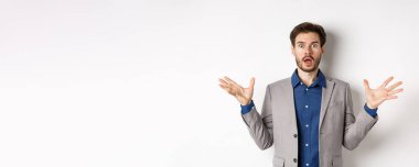 Ceketli şok olmuş sakallı adam ellerini yana yatırdı, nefes nefese kaldı ve endişeli görünüyordu, pembe arka plan giysisine karşı duruyordu..