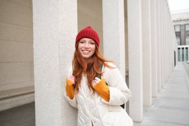 Happy redhead girl, tourist going around town, exploring sighsteeing places in city, backpacking around europe, enjoys travelling.