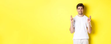 Sinirli adam şans dilemek için şans diliyor, bir şeyler umuyor, sarı arka planda duruyor..