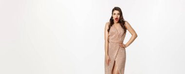 Noel partisi ve kutlama konsepti. Uzun boylu, esmer bir kadın. Şaşırmış görünüyor. Şık giyinmiş, kamera karşısında nefes nefese kalmış..