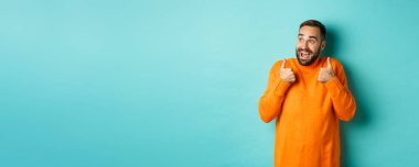 Neşeli adam övgüler yağdırıyor ve sol üst köşeye bakıyor, afallamış, süper havalı ürünler sergiliyor, açık mavi arka planda duruyor..