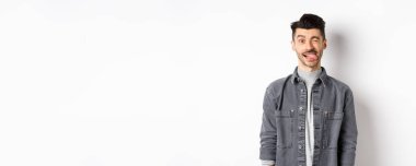 Bıyıklı komik adam dil gösteriyor ve göz kırpıyor, seni güldürüyor, beyaz arka planda duruyor..