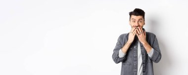 Mutluluktan gülen mutlu adam, şaşkınlık ve inançsızlıkla bak, hediyeyi al, beyaz arka planda dur..