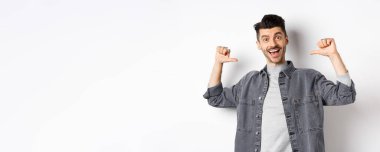 Yakışıklı ve kendine güvenen, gülümseyen, kendini üstün gören, profesyonel gibi hisseden, beyaz arka planda duran bir adam..