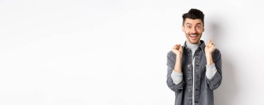 Heyecanlı ve şaşırmış adam mutlu görünüyor, ödül kazanıyor ve seviniyor, iyi haberleri duyuyor, beyaz arka planda mutlu duruyor..