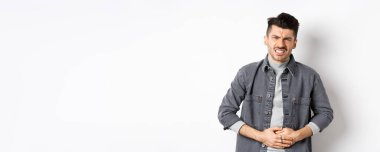 Karnı ağrıyan, karın ağrısı çeken, yemek zehirlenmesi geçiren, ishal olan, beyaz arka planda duran bir adam..