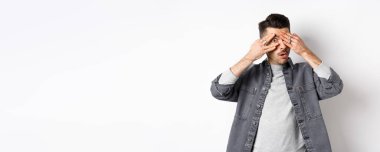 Çok ilginç. Meraklı bir adam kameraya bakıyor, şaşkın şaşkın bakıyor, beyaz arka planda duruyor..