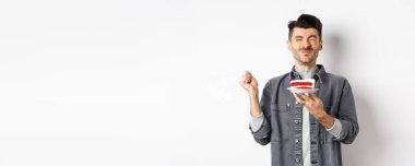 Doğum günün kutlu olsun. Pastada dilek tutan, doğum gününü kutlayan, beyaz arka planda duran çocuk..