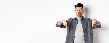 Heyecanlı adam diyor ki, vay canına, parmaklarını şaşkına çeviriyor, havalı tanıtım teklifleri sunuyor, kot ceketle beyaz arka planda duruyor..