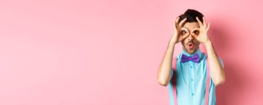 Reklamları kontrol ediyorum. Papyonlu etkileyici bir adam, el dürbününden bakıyor ve şöyle diyor: Vay canına, havalı reklamlara bakıyor, pembe arka planda duruyor..