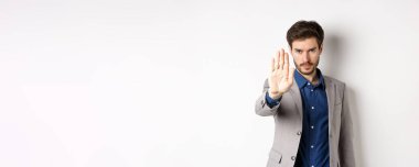 Orada dur bakalım. Takım elbiseli ciddi bir işadamı elini uzatıp, kaşlarını çatmasını, kendinden emin görünmesini, onaylamamasını, kötü bir şeyi yasaklamasını, beyaz arka planda durmasını söyler..