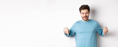 Yakışıklı beyaz adam, etkilenmiş ve mutlu yüzüyle, gülümsüyor ve 