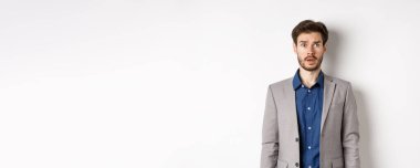 Takım elbiseli şaşkın sakallı işadamı sağ üst köşedeki logoya bakıyor..