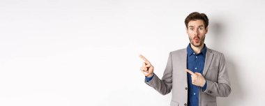 Heyecanlı, takım elbiseli yakışıklı bir adam sol pankartı gösterip 