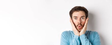 Etkilenmiş bir adamın özel teklifi kontrol edişinin yakın plan çekimi, hayret verici bir ifadeyle dokunuşunu, hayranlıkla kameraya bakışını, beyaz arka planda duruşunu..