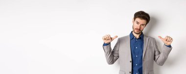 Kendine güvenen, profesyonel görünümlü, kendini gösteren, kendi reklamını yapan, beyaz arka planda duran kendine güvenen bir adam..