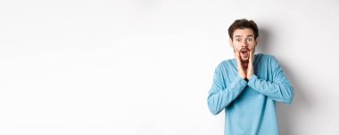 Yakışıklı adamın görüntüsü soluk soluğa kaldı ve kameraya baktı. Şaşırdı, müthiş tanıtım tekliflerine baktı, beyaz arka planda durdu..