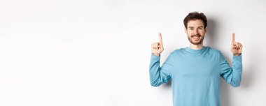 Fotokopi alanında reklam yapan, parmaklarını kaldırıp gülümseyen sakallı genç bir adamın resmi..