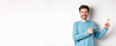 Mutlu sakallı adam reklamını yapıyor, parmaklarını doğru gösteriyor ve gülümsüyor, linke tıklamaya davet ediyor, beyaz arka planda duruyor..