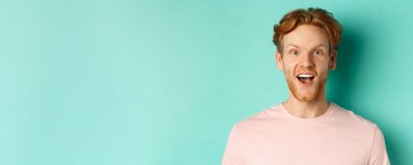 Kızıl sakallı, kaşlarını kaldıran, kameraya şaşırmış, terfiyi kontrol eden, temiz arka planda duran....