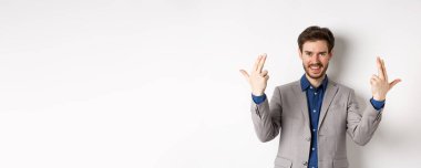 Heyecanlı ve başarılı bir iş adamı beyaz arka planda duran mutlu, motive olmuş ve pozitif hissediyor..