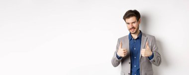 - Çok iyi. Gülümseyen yakışıklı yönetici onaylanmış, gururlu ve memnun görünüyor, evet diyor, iyi iş çıkarıyor, beyaz arka planda duruyor..