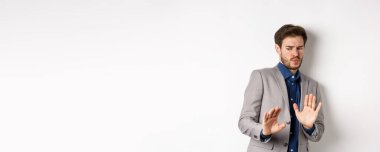 Uzak dur benden. İsteksiz işadamı endişeli bir yüz ifadesiyle geri adım atar, kötü bir teklifi engellemek için ellerini kaldırır, iğrenç bir şeyi reddeder, tiksinti duymaktan kaçınır, beyaz bir altyapısı vardır..