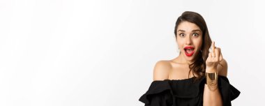 Nişan yüzüğüyle parmağını gösteren heyecanlı genç bir kadın nişanlandı ve beyaz arka planda dikilerek evet dedi..