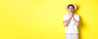 Turizm ve yaz kavramı. Korkudan atlayan, sarı arka planda duran şok olmuş bir adam..