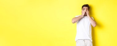 Utangaç adam gözlerini kapadı ama parmaklarının arasından sarı arka planda duran garip bir şeye baktı..