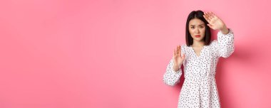 Ürkek ve korkmuş Asyalı kadın kendini savunuyor. Korumak için kollarını kaldırıyor. Kurban saldırıya uğruyor..