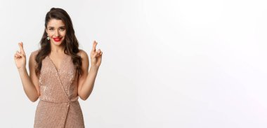 Kumarhane, kutlama ve parti kavramı. Umut dolu güzel bir kadın dilek diliyor, şans diliyor ve kendinden emin görünüyor, beyaz bir altyapısı var..