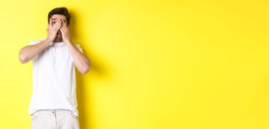 Utangaç adam gözlerini kapadı ama parmaklarının arasından sarı arka planda duran garip bir şeye baktı..