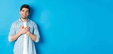 Gururu okşanmış yakışıklı bir adamın portresi. Sana teşekkür ediyor. Yüreğinin üstünde el ele tutuşuyor ve gülümsüyor..