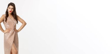 Noel partisi ve kutlama konsepti. Zarif elbiseli çekici esmer, kırmızı rujlu, hoşnutsuz ve kızgın solcu, beyaz arka planda duruyor..