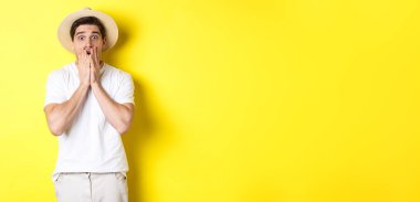 Turizm ve yaz kavramı. Korkudan atlayan, sarı arka planda duran şok olmuş bir adam..